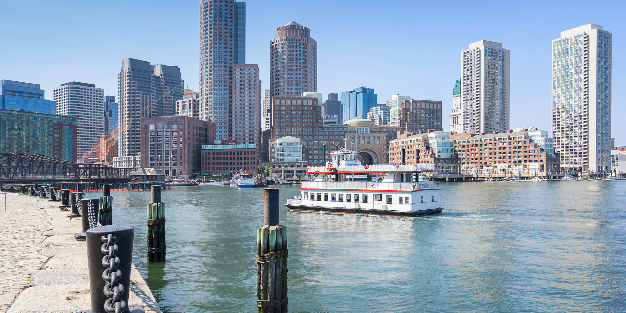 Sightseeing ferry passing the Boston skyline and Fan Pier waterfront on a clear summer day, Massachusetts