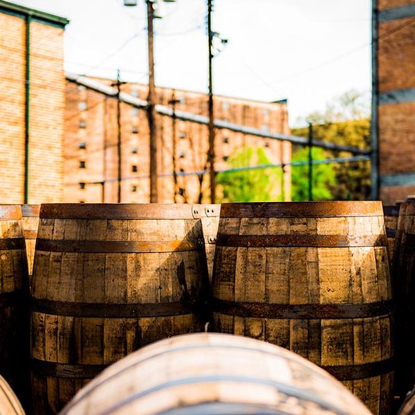 Bourbon barrels stacked outside a brick distillery warehouse on the Urban Bourbon Trail in Louisville, Kentucky
