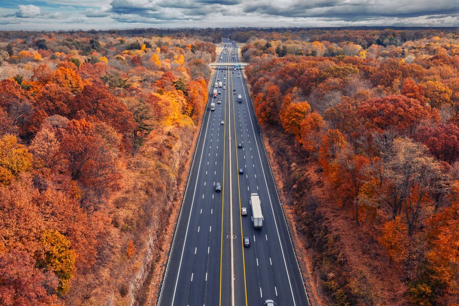 Aerial view of a highway cutting through blazing autumn forest along the Kancamagus, New Hampshire