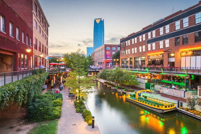 Bricktown Canal in Oklahoma City lit up in the evening, near the city's historic Stockyards district.