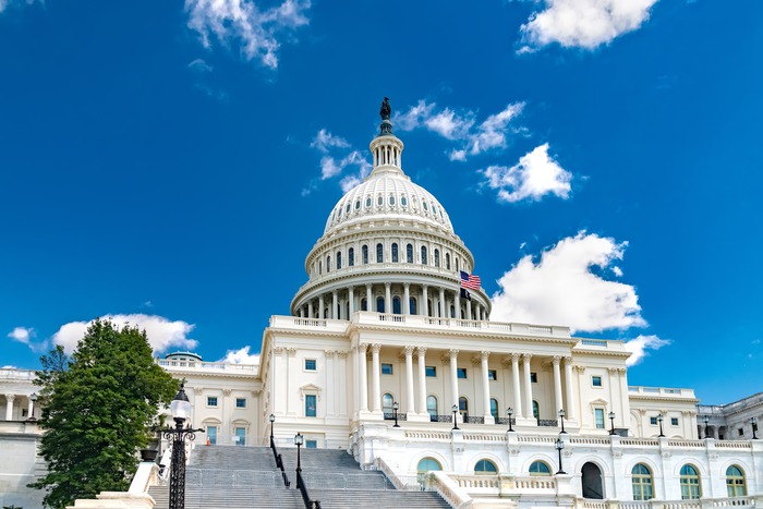 The United States Capitol Building dome in Washington, DC, under a clear blue sky.