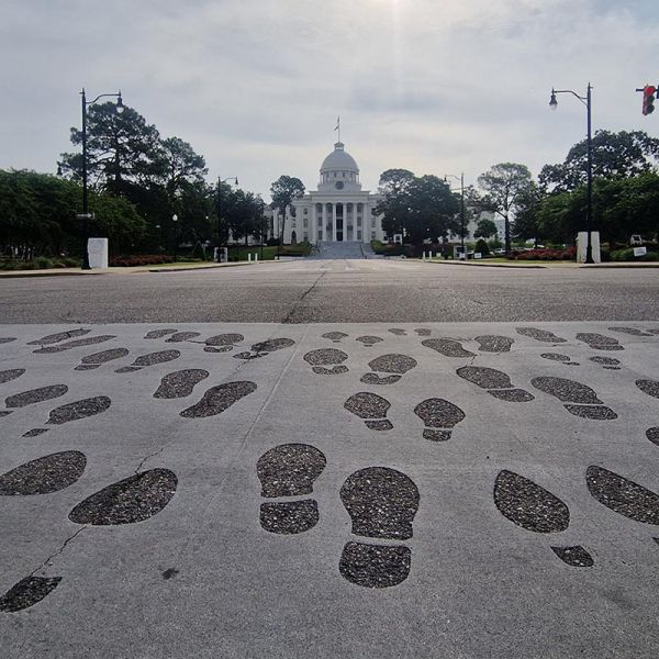 Footprints set into the pavement on Dexter Avenue commemorate the 1965 Selma to Montgomery civil rights march, leading towards the white-domed Alabama State Capitol
